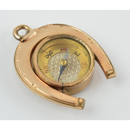 465 - Gold plated horseshoe watch fob with agate face and compass, 3.5cm long.