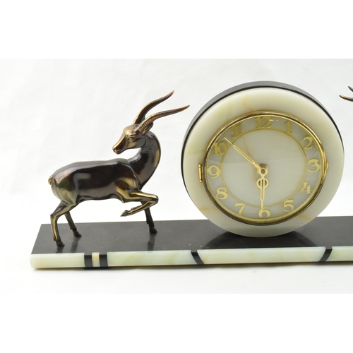 493 - French Art Deco mantle clock, flanked by gazelles with raised legs, 61cm long.