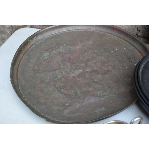 256 - A collection of Eastern copper and brass trays, largest 63cm diameter, some with incised decoration,... 