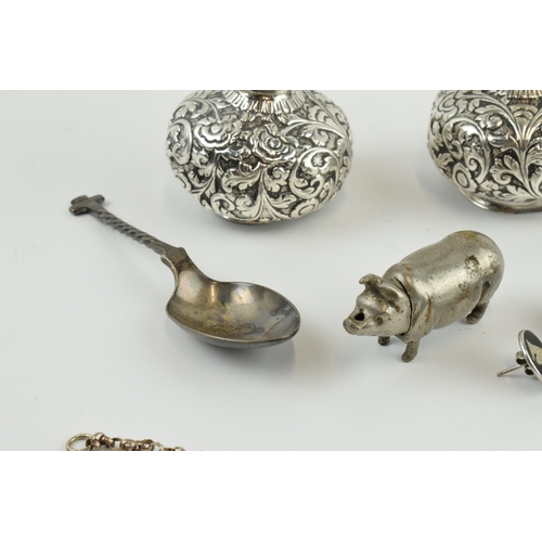 414 - Interesting items to include a novelty plated vesta case in the form of a pig, a pair of white metal... 