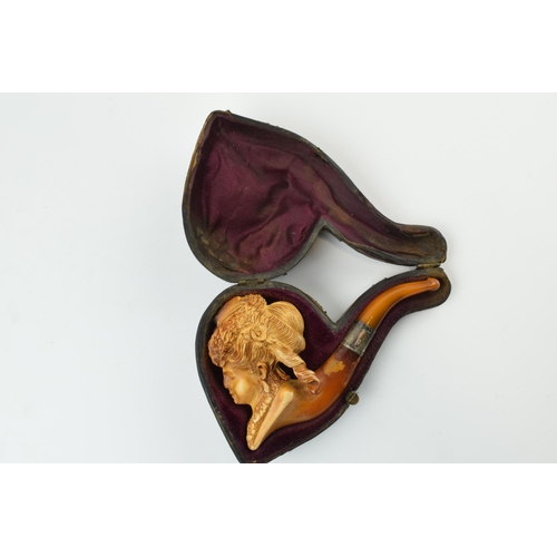 179 - Antique meerschaum pipe with amber mouthpiece and white metal collar, with carved decoration in the ... 