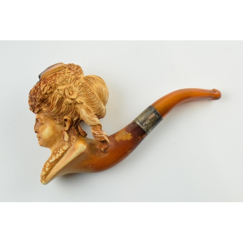 179 - Antique meerschaum pipe with amber mouthpiece and white metal collar, with carved decoration in the ... 