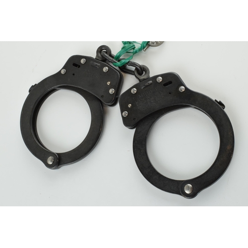 180 - A pair of Smith & Wesson handcuffs, M10 0-1, with key.