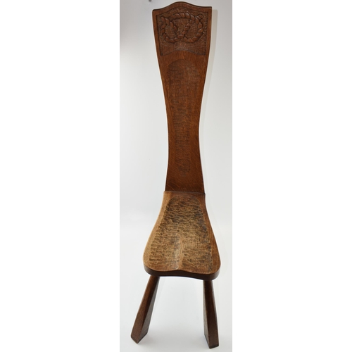 202 - Golden oak spinning stool with carved Stafford Knot to top of the back, in three legs, 99cm tall.