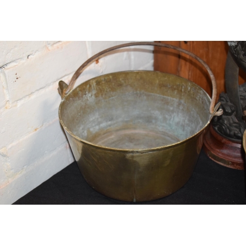 301 - A pair of antique brass jam pans with heavy duty handles, together with a spelter figure of wood eff... 