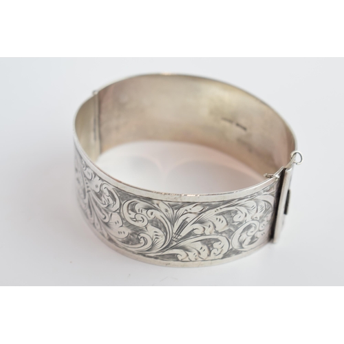 405B - Silver wide bangle with scroll decoration to ront and back, Birmingham 1933, 35.4 grams.