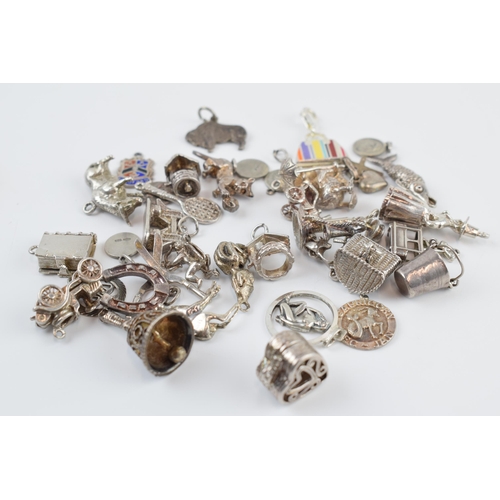 405C - A collection of mainly silver charms of varying forms and sizes, approx. 90 grams.