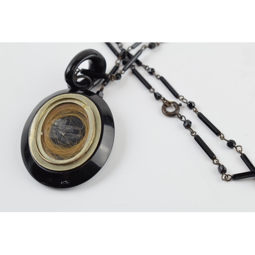 405H - Jet mourning locket on chain, slight chip to top of locket.