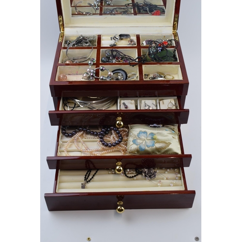 211 - A modern wooden jewellery case with folding lid and pull out drawers with a collection of costume je... 