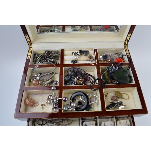 211 - A modern wooden jewellery case with folding lid and pull out drawers with a collection of costume je... 