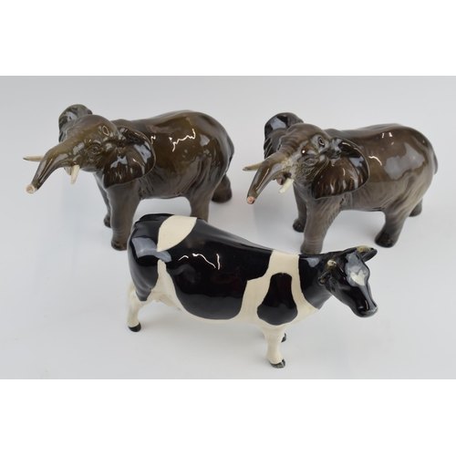 73 - A pair of Beswick elephants (1 nip to tusk) and a Friesian cow (1 horn af) (3).