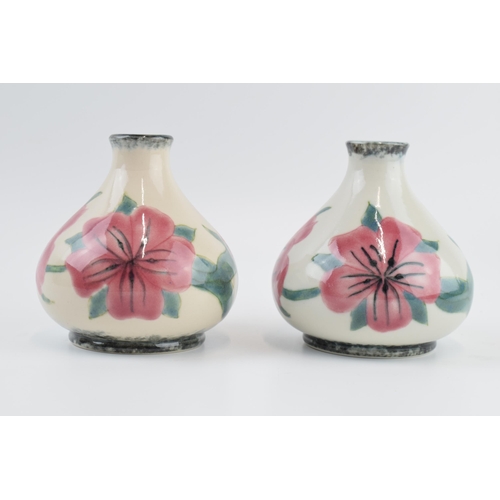 82 - A pair of Cobridge Stoneware pottery vases with pink floral design, 10cm tall (2).