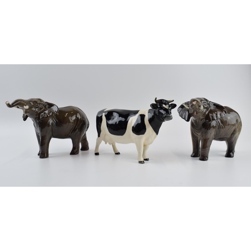 75A - A pair of Beswick elephants (1 nip to tusk) and a Friesian cow (1 horn af) (3).