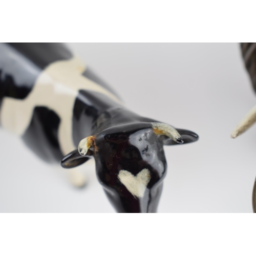 75A - A pair of Beswick elephants (1 nip to tusk) and a Friesian cow (1 horn af) (3).