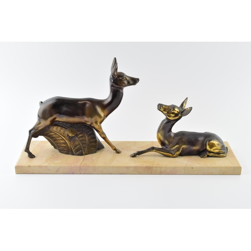 179 - French Art Deco spelter figures of a pair of deers mounted on a marble base, 45cm long.