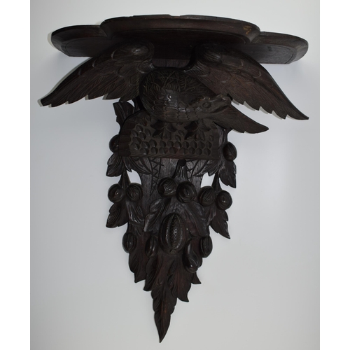 195 - Large Black Forest carved shelf with an eagle amongst foliage, 56cm long.