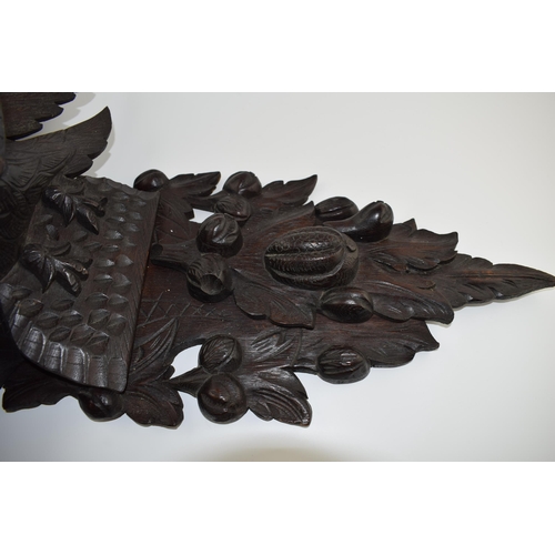 195 - Large Black Forest carved shelf with an eagle amongst foliage, 56cm long.