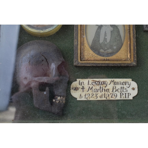 197 - Framed Memento Mori containing lock of hair, carved wooden skull, crucifix, and plaque that reads 