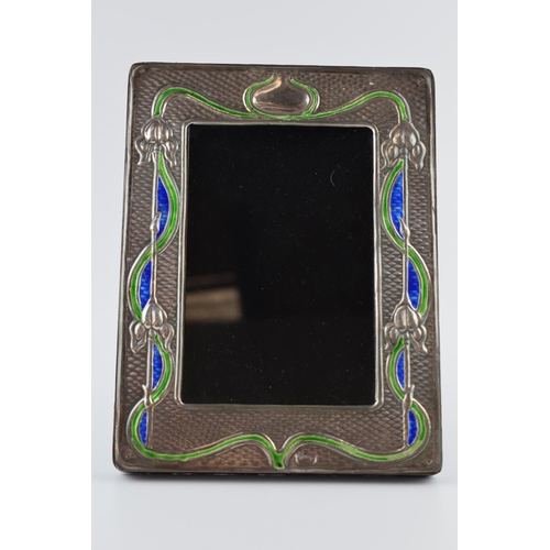 453 - Sterling silver fronted photo frame with enamelled decoration in the Art Nouveau style, 19.5cm tall.