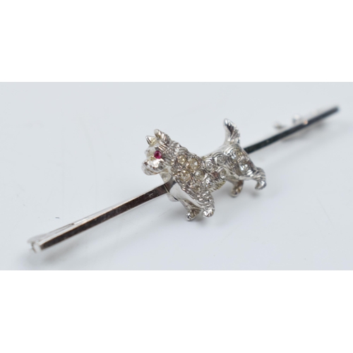 545 - 14ct white gold bar brooch with a terrier dog set with a ruby and diamonds, 3.9 grams, 5cm wide.