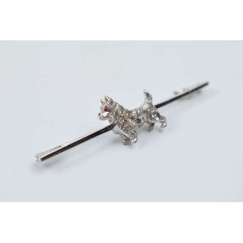 545 - 14ct white gold bar brooch with a terrier dog set with a ruby and diamonds, 3.9 grams, 5cm wide.