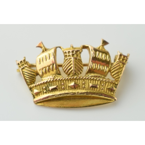 565 - 9ct gold brooch in the form of a royal crown formed with galleons, 2.5 grams, 25mm wide.