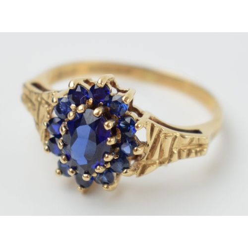 572 - 9ct gold ladies ring set with sapphires with textured shoulder, 2.6 grams, size R, in box.