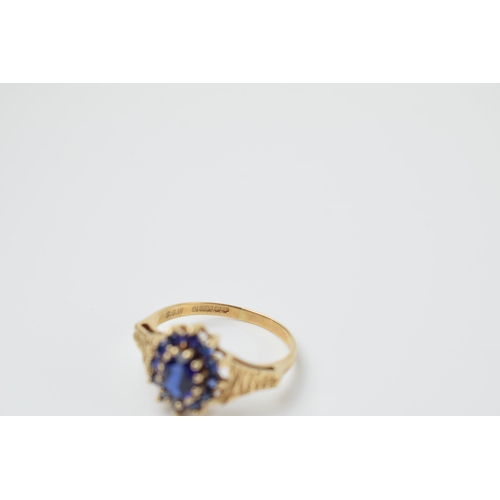 572 - 9ct gold ladies ring set with sapphires with textured shoulder, 2.6 grams, size R, in box.