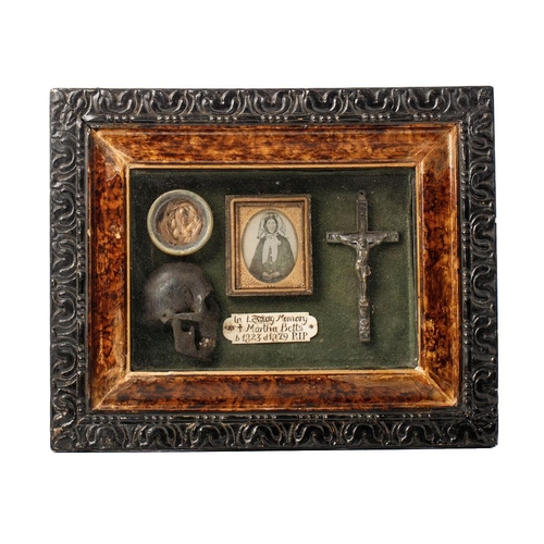 197 - Framed Memento Mori containing lock of hair, carved wooden skull, crucifix, and plaque that reads 