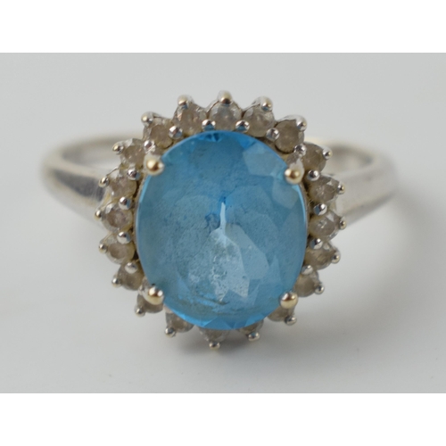 608 - 9ct gold ring with large pale blue stone with diamonds surrounding, 4.9 grams, size V.