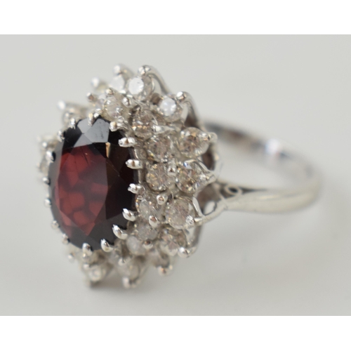 634 - 18ct white gold ring set with 1.25ct of diamond with large garnet stone, 7.7 grams, size O.