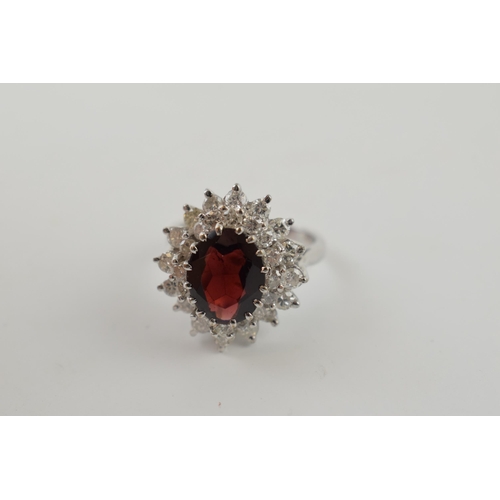 634 - 18ct white gold ring set with 1.25ct of diamond with large garnet stone, 7.7 grams, size O.