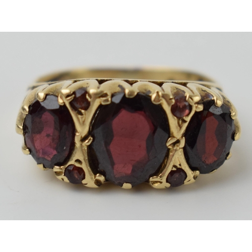 643 - 9ct gold ring set with 3 large garnets and 4 small, 4.1 grams, size N.