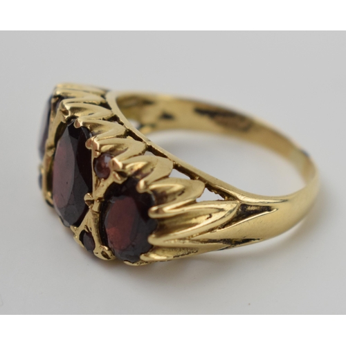 643 - 9ct gold ring set with 3 large garnets and 4 small, 4.1 grams, size N.