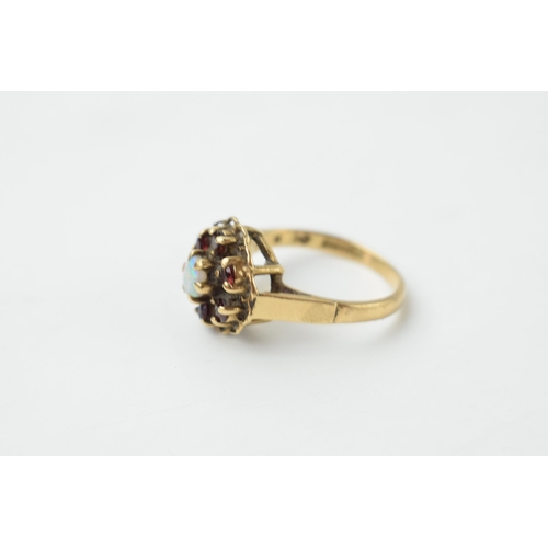 652 - 9ct gold ring to include 6 garnets surrounding an opal, 3.4 grams, size N/O.