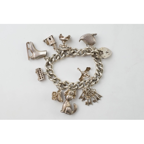 674 - Silver charm bracelet, 55.7 grams, to include an ice skating boot, a duck, keys and others.