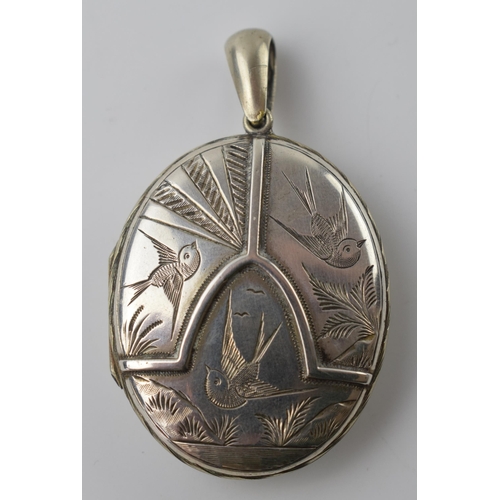 677 - Victorian silver locket (front and back) with birds in flight to front, containing images.