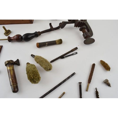 286 - A collection of vintage gun cleaning and cartridge making accessories to include rods, brushes and v... 