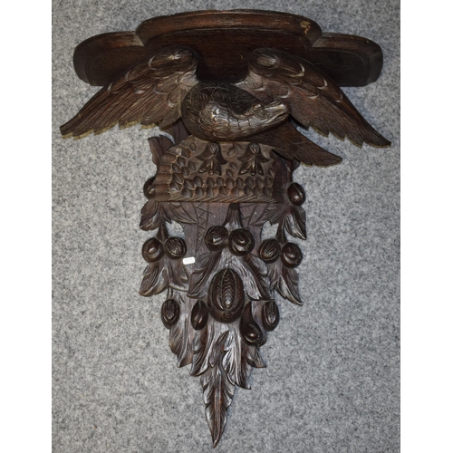 195 - Large Black Forest carved shelf with an eagle amongst foliage, 56cm long.