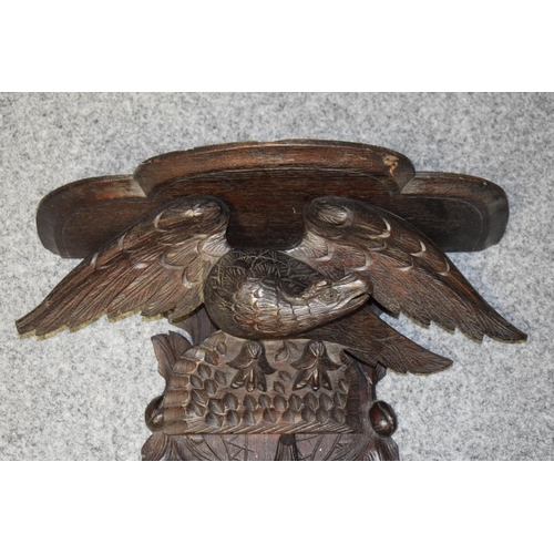 195 - Large Black Forest carved shelf with an eagle amongst foliage, 56cm long.