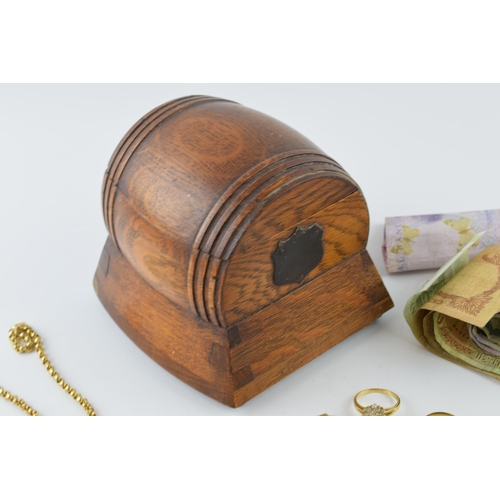 224 - An Edwardian oak barrel jewellery box with musical element with gold plated jewellery and foreign ba... 