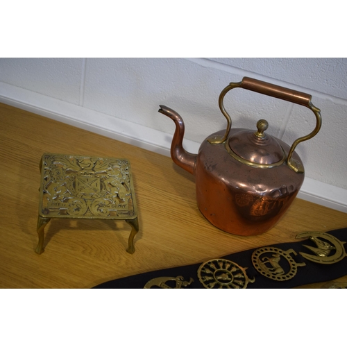 379 - A pair of horse leathers with horse brasses with a copper kettle and a brass trivet (4).