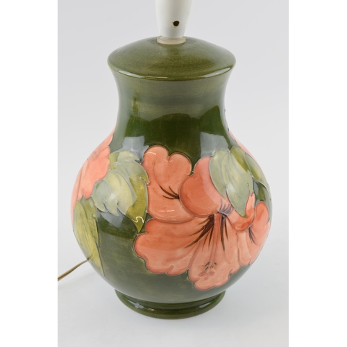 134 - Large Moorcroft Hibiscus on green bulbous lampbase, 33cm tall inc fittings.