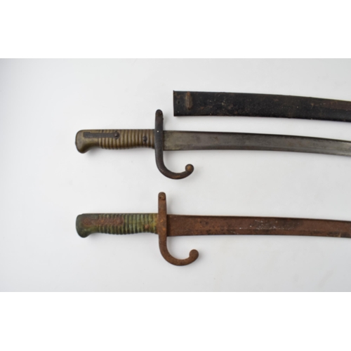 426 - 19th century French Chassepot bayonet in scabbard together with another similar example without scab... 