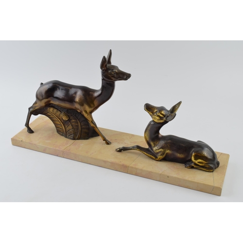 437 - French Art Deco spelter figures of a pair of deers mounted on a marble base, 45cm long.