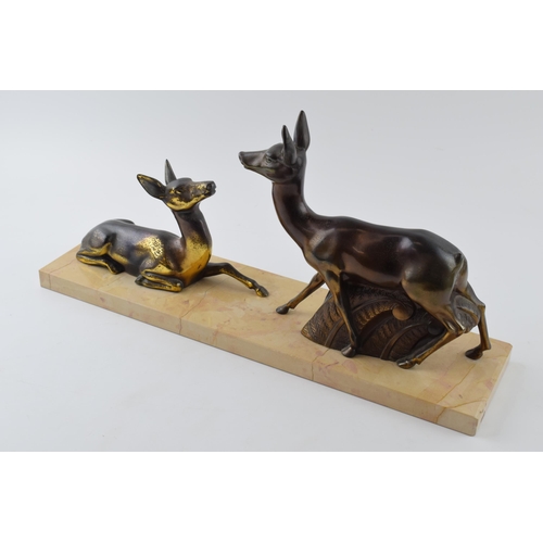 437 - French Art Deco spelter figures of a pair of deers mounted on a marble base, 45cm long.