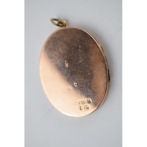 286 - 9ct gold large oval locket with striped decoration, Chester 1919, 9.9 grams total weight.