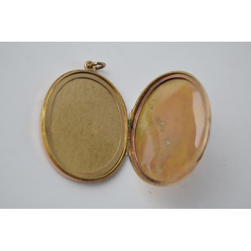 286 - 9ct gold large oval locket with striped decoration, Chester 1919, 9.9 grams total weight.