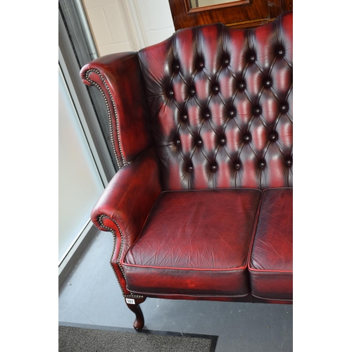 508 - Queen Anne revival chesterfield wingback three seater sofa, with high back, in red leather with butt... 