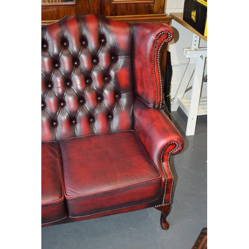 508 - Queen Anne revival chesterfield wingback three seater sofa, with high back, in red leather with butt... 